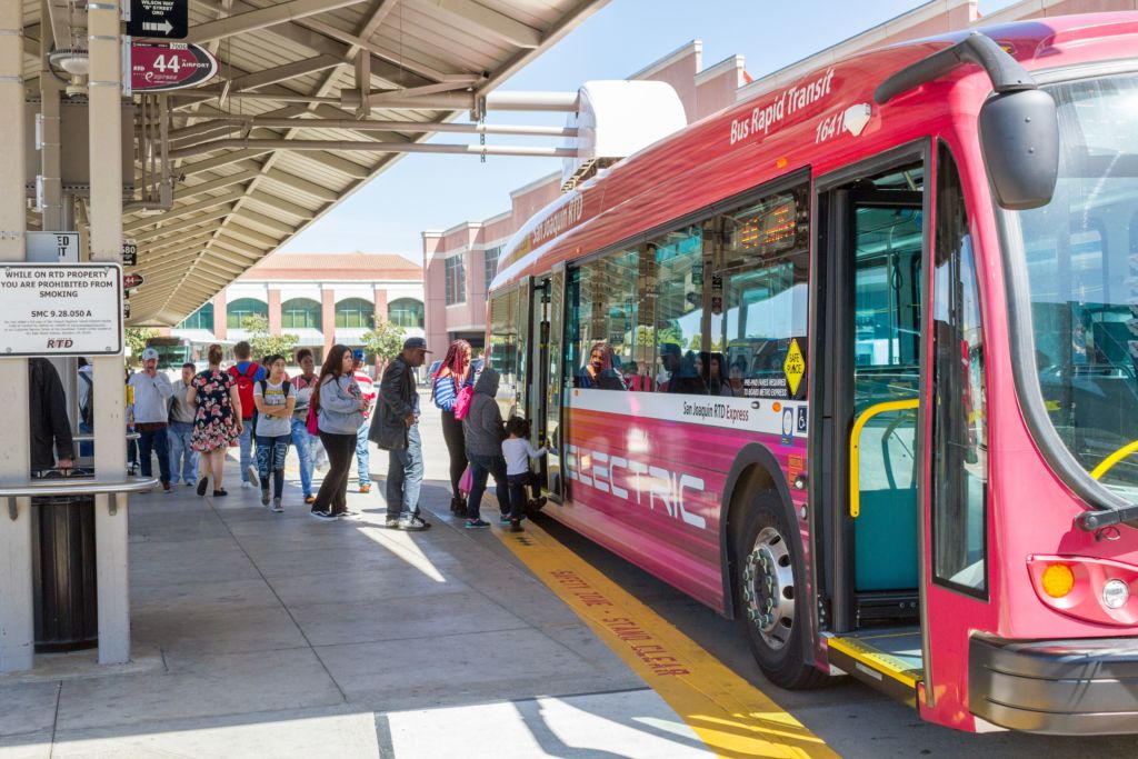 Photo of passengers loading a electric BRT express bus at the Downtown Transit Center
