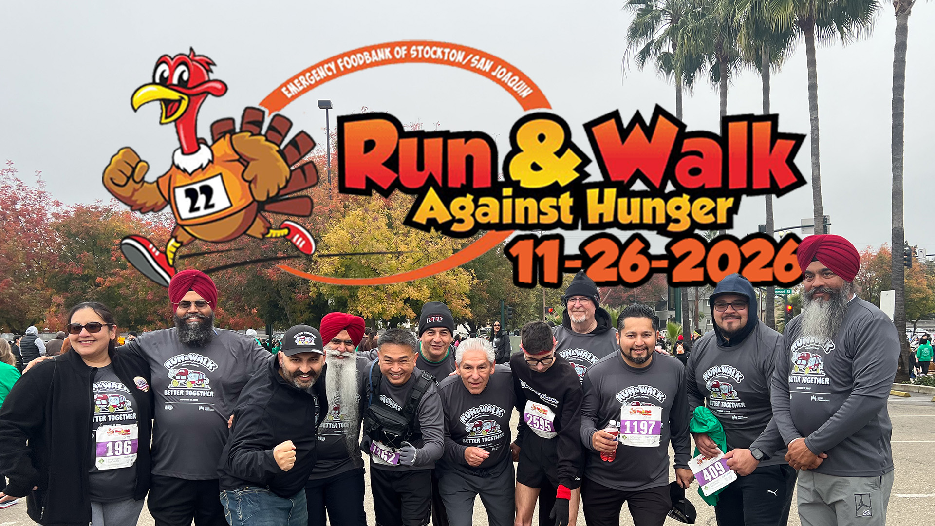 A group of RTD employees pose for a race with graphics reading "run and walk against hunger" in the background. There is an image of a cartoon turkey in sneakers.